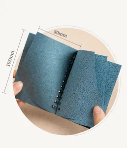 Detailopname van een mini spiraalnotitieboek 80x105mm met gestructureerd blauw katoenpapier