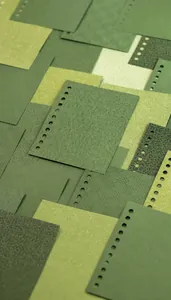 Detailopname van groen speciaal papier met textuur en voorgeperforeerde gaten voor journals