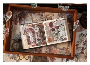 Gros plan du kit de scrapbooking vintage avec autocollants papillon et fleurs sur papier vieilli