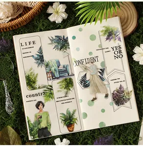 Detailed view of fern leaf stickers and botanical illustrations on an open notebook