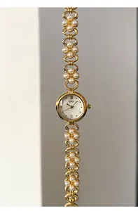 Close-up of GEDI ladies' gold watch with pearl bracelet and floral accents