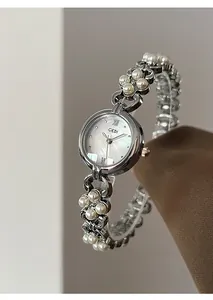 Close-up of elegant women's watch featuring a mother of pearl dial and pearl chain strap