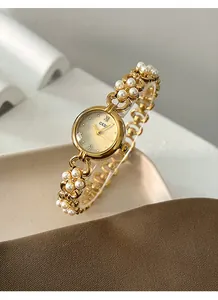 Close-up of GEDI quartz watch with gold chain bracelet and elegant white pearls