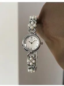 Macro shot of a GEDI women's silver quartz watch with a white pearl bracelet band