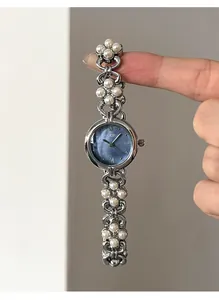 Detail of GEDI watch showing blue sunray dial and pearl flower chain strap design