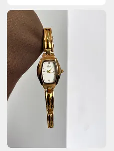 Detail van Gedi gouden horloge met tonneau-wijzerplaat en gepolijste schakelarmband
