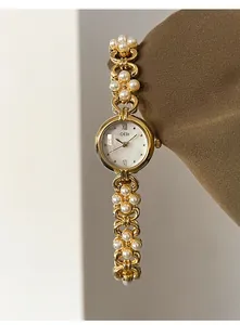 Detailed shot of GEDI women's watch with golden metal case and pearl chain strap