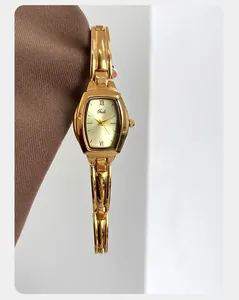 Macro-opname van een vintage gouden tonneau horloge met Romeinse cijfers op textiel