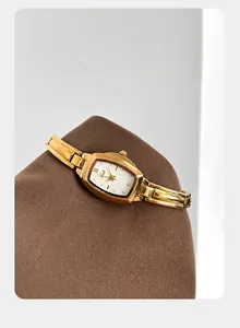 Macro-opname van een Gedi goudkleurig tonneau horloge met Romeinse cijfers en witte wijzerplaat