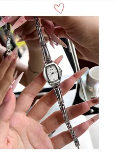 Detail van elegant zilveren tonneau quartz horloge met slanke metalen H-schakel