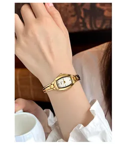 Elegant goudkleurig tonneau-horloge met metalen kettingband om de pols gedragen foto