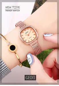 Gros plan d'une montre à quartz carrée or rose avec bracelet en maille au poignet