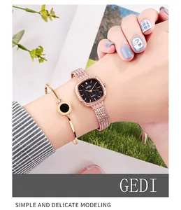 Détail d'une montre carrée or rose et bracelet assorti au poignet sur fond de plante
