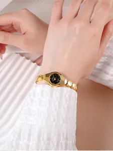 Détail de la montre GEDI en alliage doré avec boîtier polygonal et cadran noir au poignet