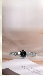 Détail macro du bracelet argenté poli et du cadran noir d'une montre à quartz élégante