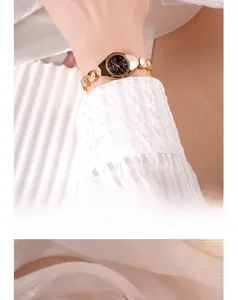Détail de la montre bracelet dorée GEDI avec cadran noir et design géométrique