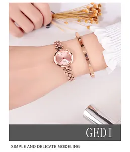 Macro view of rose gold quartz watch with a screw-patterned bangle on a wrist