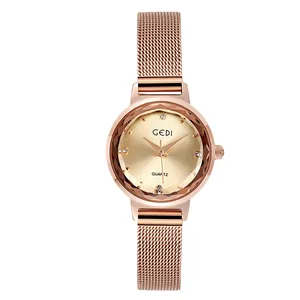 Dettaglio orologio in oro rosa con cinturino mesh e cristallo sfaccettato sul quadrante