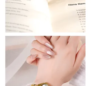 Détail d'une montre à quartz dorée avec un petit cadran rond et du nail art pailleté