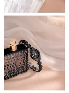 Gros plan d'une montre quartz élégante avec bracelet en cristal noir facetté et doré