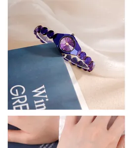 Gros plan d'une montre à quartz violette avec cadran géométrique et bracelet perlé