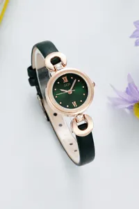 Détail d'une élégante montre à quartz avec bracelet en cuir vert et accents dorés