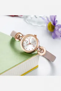 Détail d'une montre à quartz pour femme avec bracelet rose et attaches fer à cheval dorées
