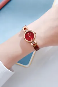 Montre élégante en or rose avec bracelet fin en cuir rouge et cadran à chiffres romains