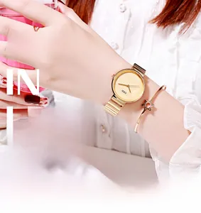 Detail shot of GEDI gold quartz watch with matching star bracelet and wavy ring set
