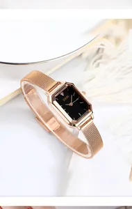 Close-up of minimalist rose gold mesh strap watch with elegant black square dial