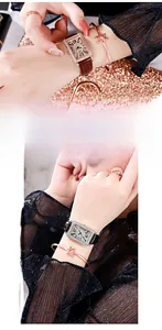 Close-up of rectangular crystal-encrusted watch with leather strap and rose gold jewelry