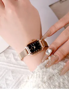 Close-up of elegant rose gold rectangular watch with black dial and Milanese mesh strap