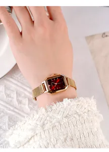 Close-up of the red gradient dial and rose gold mesh strap on this elegant women's watch