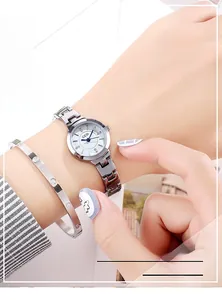 Close-up of silver steel watch with blue hands and matching crystal screw-style bracelet