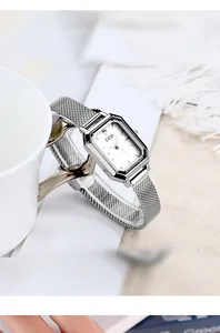 Detail of GEDI square vintage mesh watch leaning on white ceramic cup in a clean setting