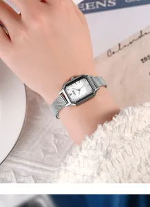 Close-up of a silver rectangular quartz watch with mesh strap on a female wrist