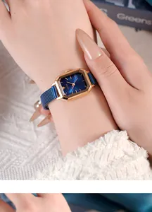 Detail of GEDI gold octagonal watch with blue dial and mesh strap on woman's wrist