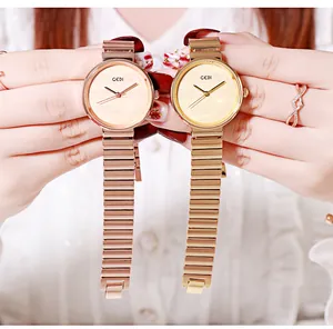 Close-up of elegant gold and rose gold quartz watches with bamboo style metal bracelet