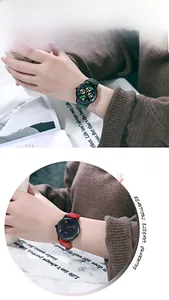 Detail of red and green leather strap watches with black dials on model wrist