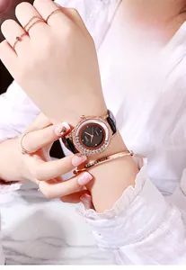 Détail d'une montre de luxe pour femme avec lunette en strass et bracelet en cuir marron
