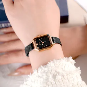 Elegant women's octagonal rose gold watch with black dial and mesh strap on wrist