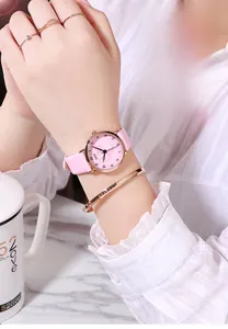 Close-up of floral dial watch with pink leather strap and rose gold metal case