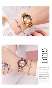 Dettaglio di orologio in oro rosa con diamanti e set di bracciali sul polso