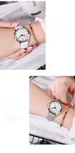 Detail of GEDI floral relief watch dial with white and grey leather straps on a table