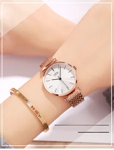 Detail of rose gold mesh strap watch and matching Roman numeral bangle on a wrist