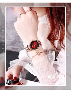Dettaglio dell'orologio in maglia oro rosa con quadrante sfumato rosso e nero e strass