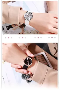 Close-up of minimalist quartz watch with Roman numerals and leather strap on a wrist