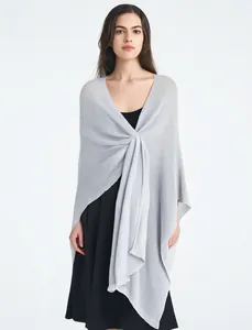 Close-up of light gray knitted shawl with fine texture and elegant drape over a black dress