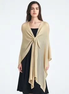 Detail of elegant champagne gold knit shawl showing the fine texture and draped fabric