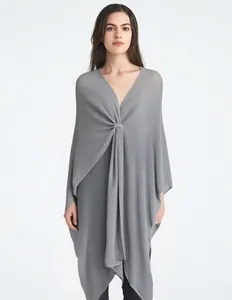 Detail of the twisted front knot design on a grey V-neck knitted shawl poncho for women